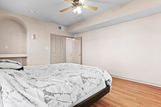 bedroom with hardwood / wood-style flooring, a closet, and ceiling fan