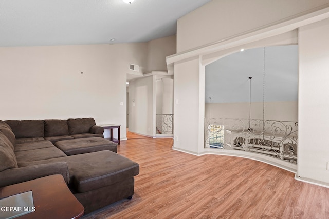 living room featuring high vaulted ceiling and light hardwood / wood-style floors