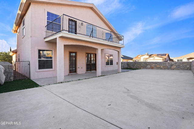 rear view of house featuring a patio area and a balcony