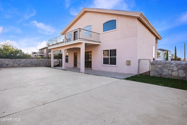 back of house with a balcony and a patio