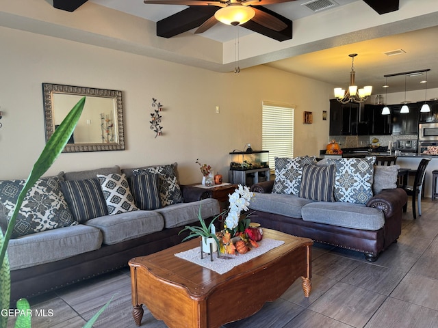 living room with ceiling fan with notable chandelier and dark wood-type flooring