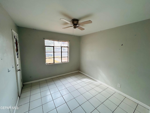 tiled spare room featuring ceiling fan