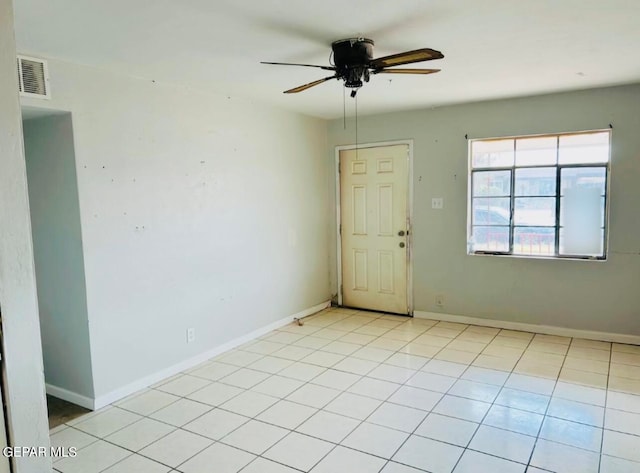 tiled spare room with ceiling fan