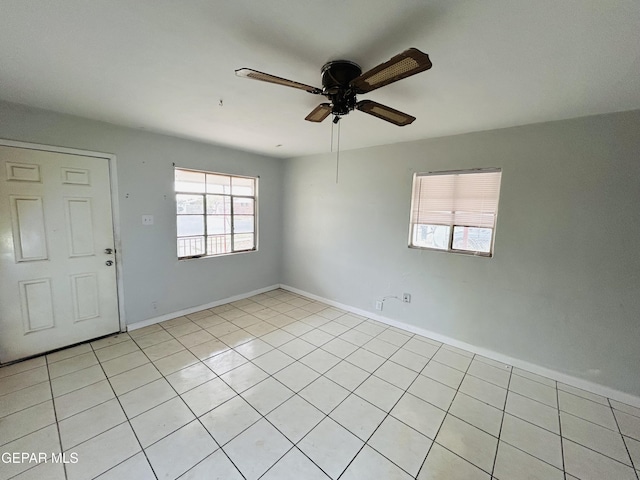 tiled spare room featuring ceiling fan