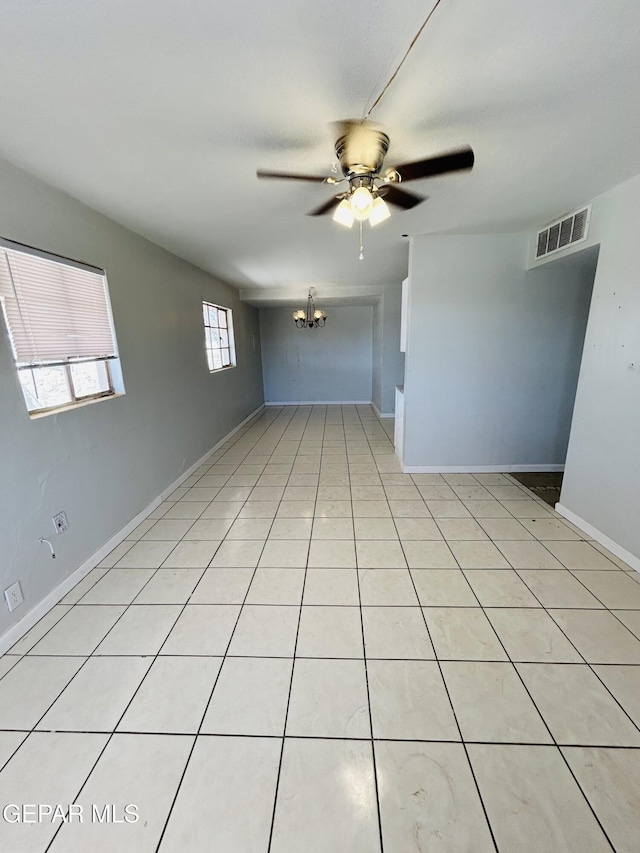 empty room with ceiling fan with notable chandelier