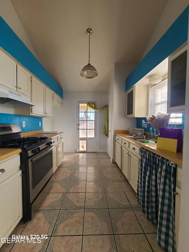 kitchen featuring lofted ceiling, stainless steel range with gas cooktop, hanging light fixtures, and a healthy amount of sunlight