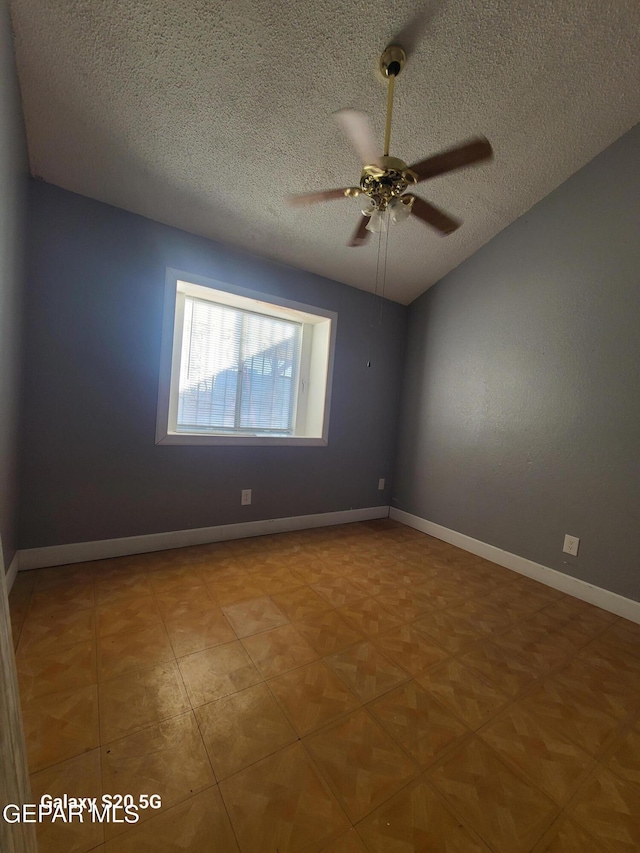 empty room with ceiling fan and a textured ceiling