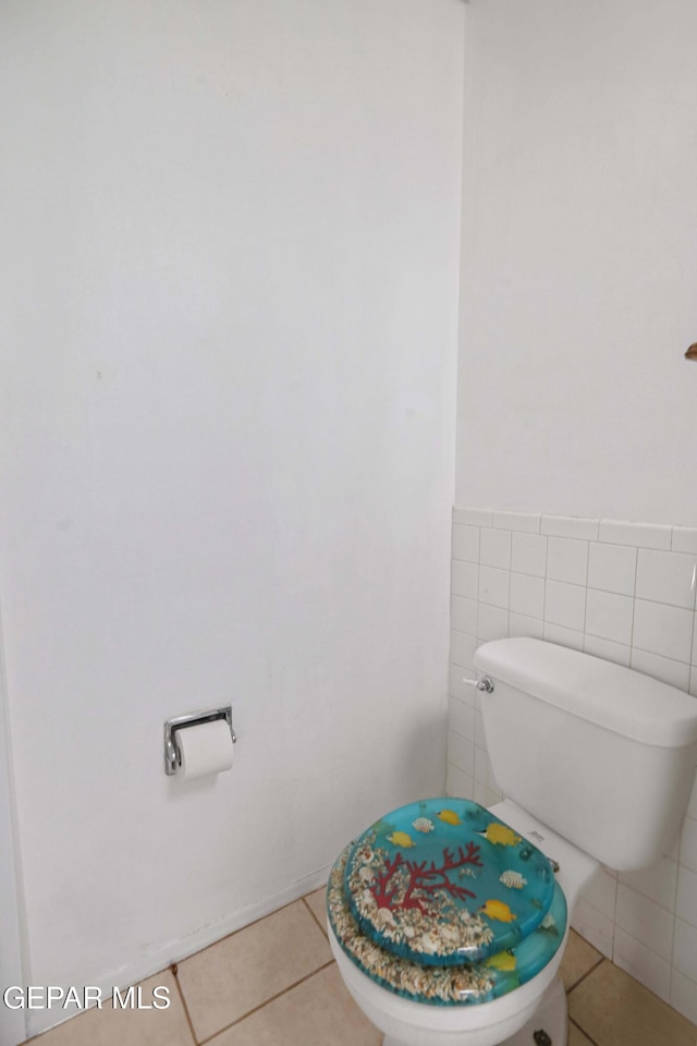 bathroom with tile patterned flooring, tile walls, and toilet