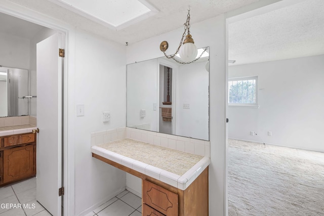 bathroom featuring a textured ceiling and tile patterned floors