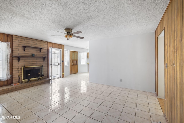 unfurnished living room with wooden walls, plenty of natural light, and a textured ceiling