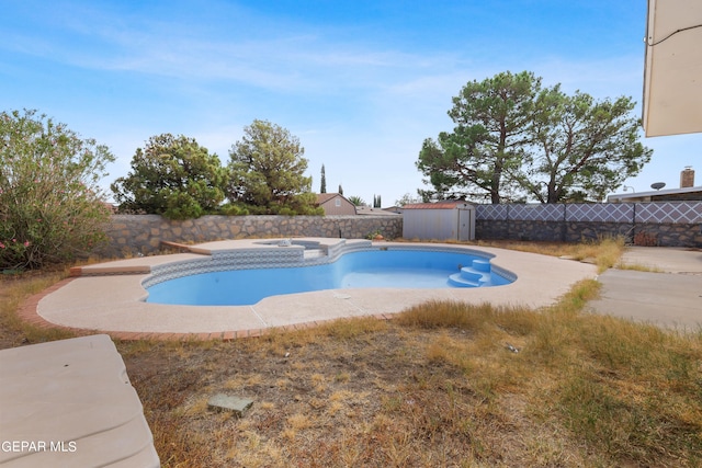 view of pool featuring a storage shed, an in ground hot tub, and a patio area