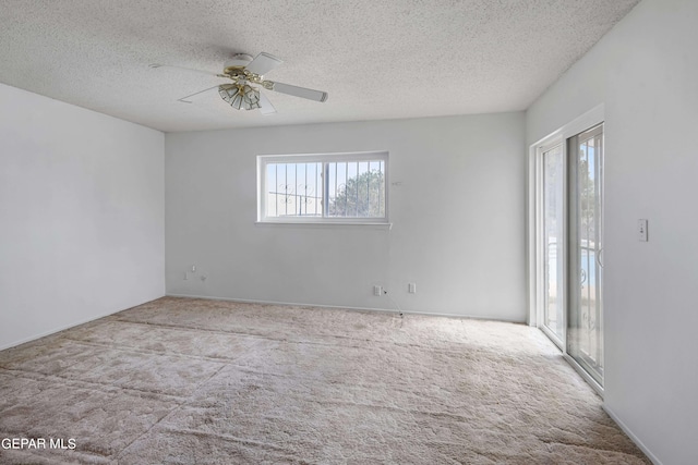 unfurnished room featuring light carpet, a textured ceiling, plenty of natural light, and ceiling fan