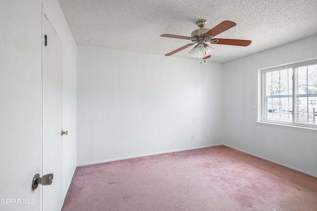 carpeted empty room featuring ceiling fan and a textured ceiling