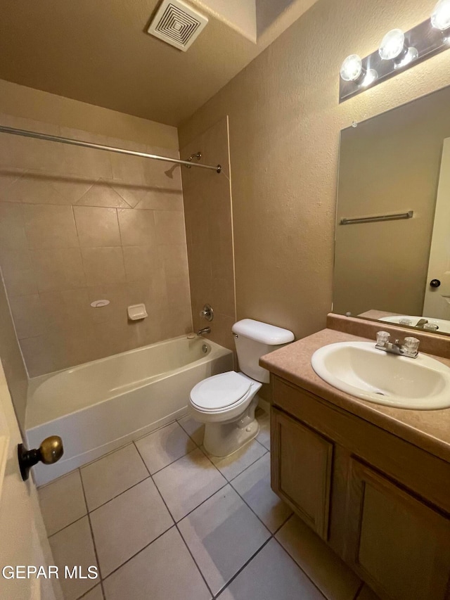 full bathroom with vanity, tile patterned flooring, toilet, and tiled shower / bath