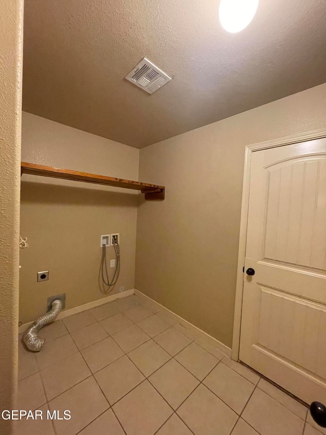 washroom featuring hookup for a washing machine, light tile patterned flooring, a textured ceiling, and hookup for an electric dryer