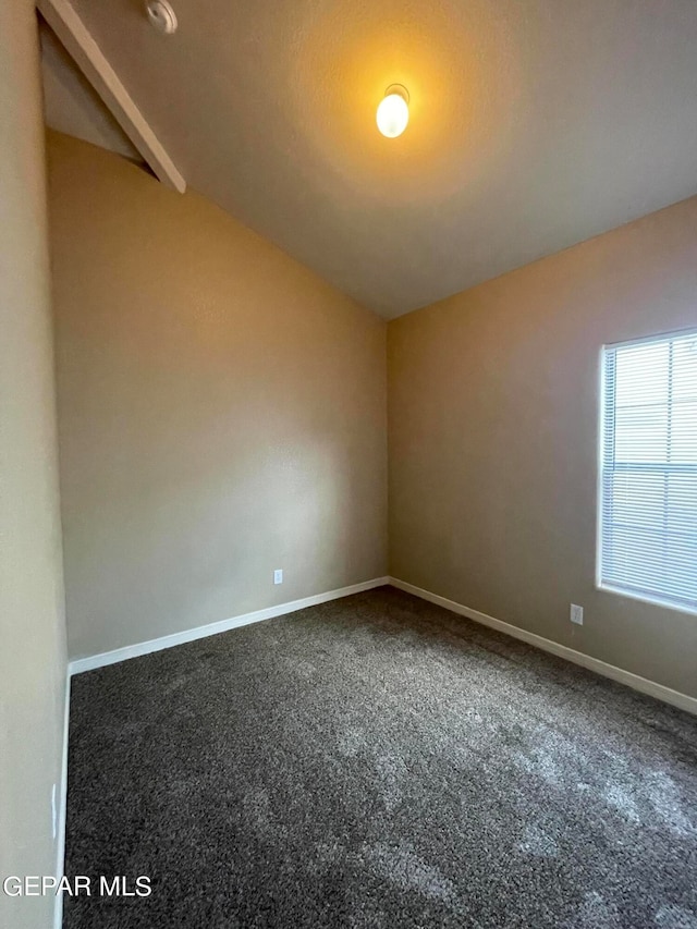 empty room with vaulted ceiling and carpet flooring