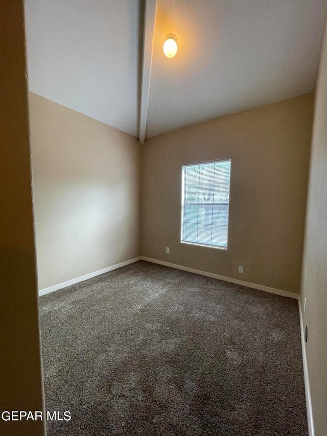 empty room with lofted ceiling with beams and carpet