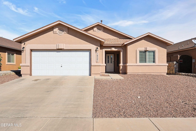 ranch-style house with a garage, stucco siding, and driveway