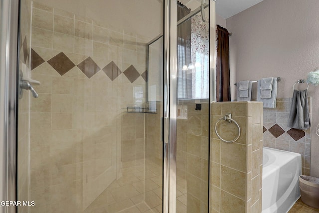 bathroom featuring tile walls and plus walk in shower