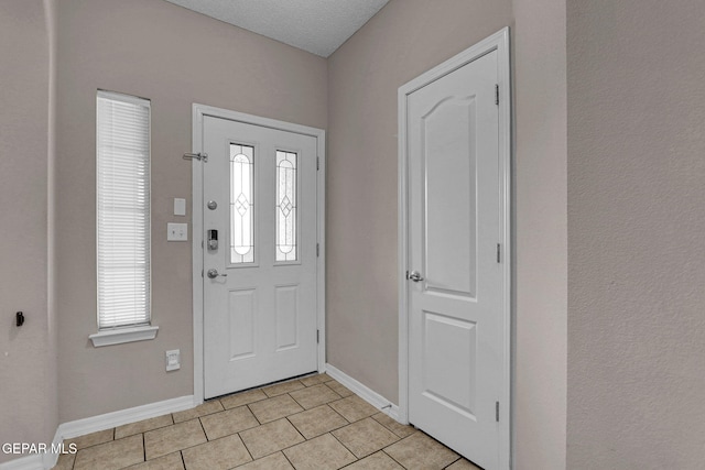 tiled foyer featuring a textured ceiling