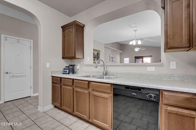 kitchen featuring dishwasher, sink, a notable chandelier, pendant lighting, and light tile patterned floors