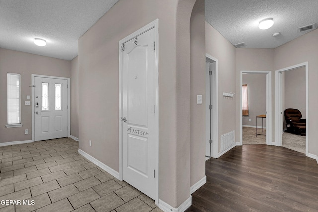 entrance foyer with light hardwood / wood-style flooring and a textured ceiling