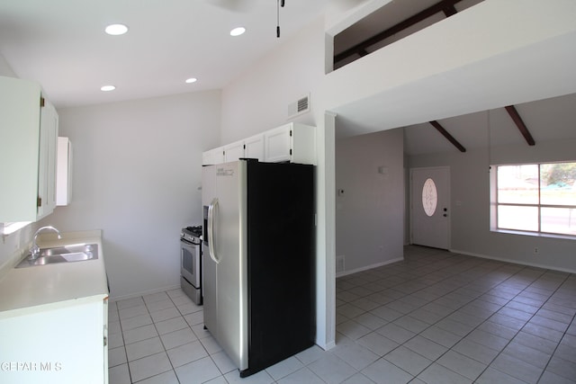 kitchen with vaulted ceiling with beams, light tile patterned floors, sink, white cabinetry, and stainless steel appliances