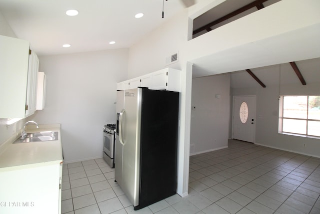 kitchen featuring beamed ceiling, light tile patterned floors, sink, white cabinetry, and appliances with stainless steel finishes