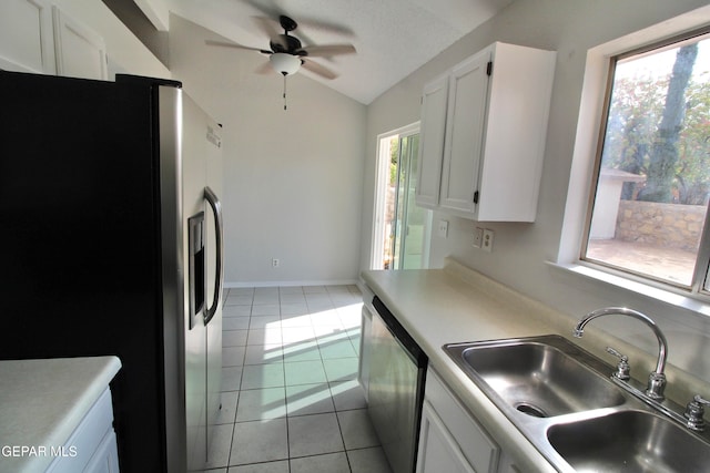 kitchen featuring sink, lofted ceiling, white cabinets, appliances with stainless steel finishes, and light tile patterned floors