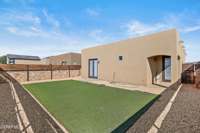 back of property featuring a lawn and a patio