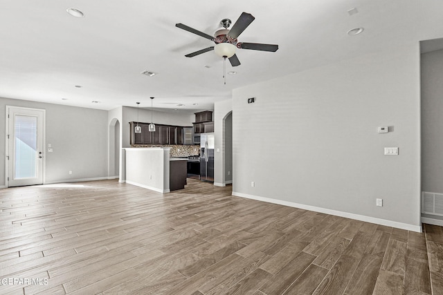 unfurnished living room with wood-type flooring and ceiling fan