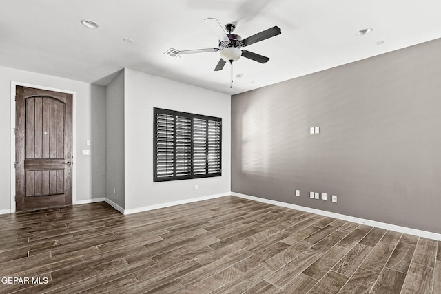 spare room with dark wood-type flooring and ceiling fan