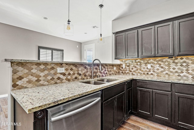 kitchen featuring light hardwood / wood-style floors, tasteful backsplash, sink, dishwasher, and hanging light fixtures