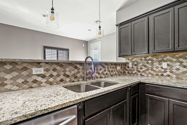 kitchen featuring hanging light fixtures, sink, stainless steel dishwasher, and tasteful backsplash