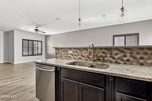 kitchen featuring tasteful backsplash, sink, hanging light fixtures, light hardwood / wood-style flooring, and dishwasher