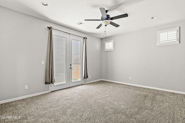 carpeted spare room with ceiling fan and french doors