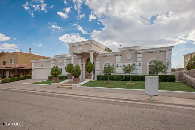 mediterranean / spanish-style home featuring a garage and a front lawn