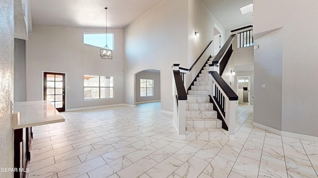 foyer with plenty of natural light, high vaulted ceiling, and a chandelier