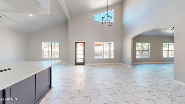 interior space featuring ceiling fan with notable chandelier and high vaulted ceiling