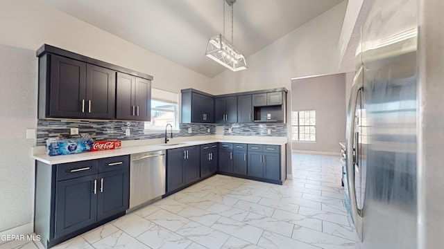 kitchen with pendant lighting, sink, tasteful backsplash, high vaulted ceiling, and appliances with stainless steel finishes