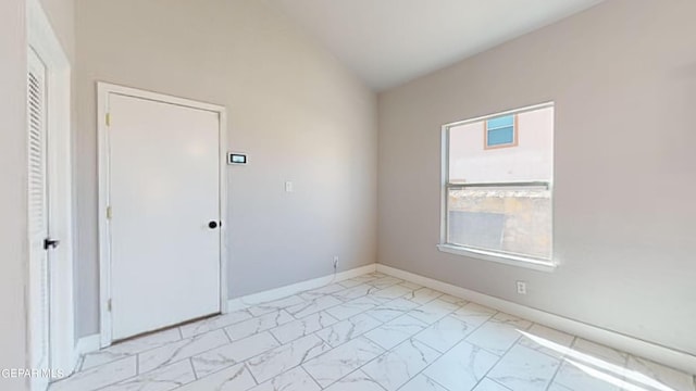 spare room featuring vaulted ceiling