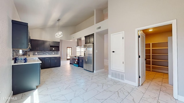 kitchen with high vaulted ceiling, tasteful backsplash, pendant lighting, wall chimney range hood, and stainless steel fridge with ice dispenser