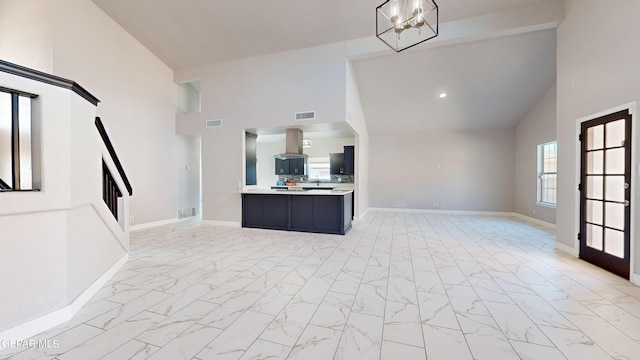 kitchen featuring high vaulted ceiling, island range hood, and a chandelier