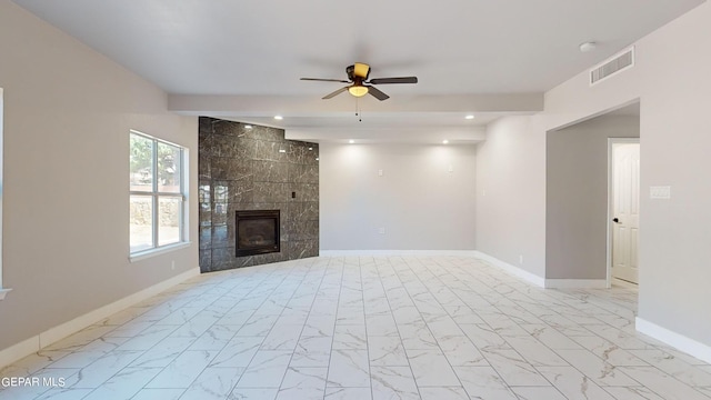 unfurnished living room featuring ceiling fan and a fireplace