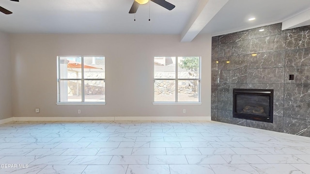 unfurnished living room with ceiling fan, beamed ceiling, and a wealth of natural light