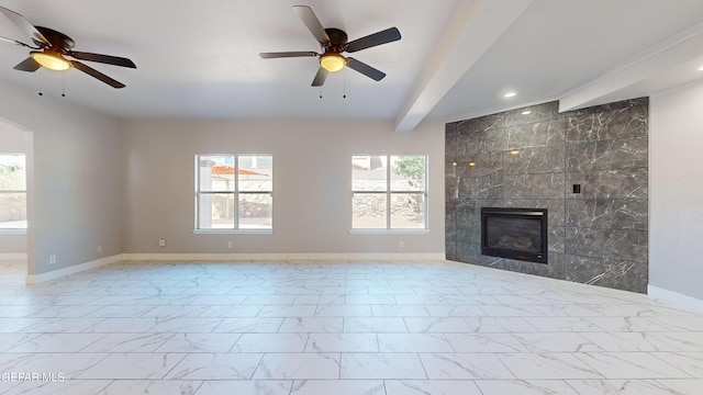 unfurnished living room featuring ceiling fan, tile walls, a tiled fireplace, and beam ceiling