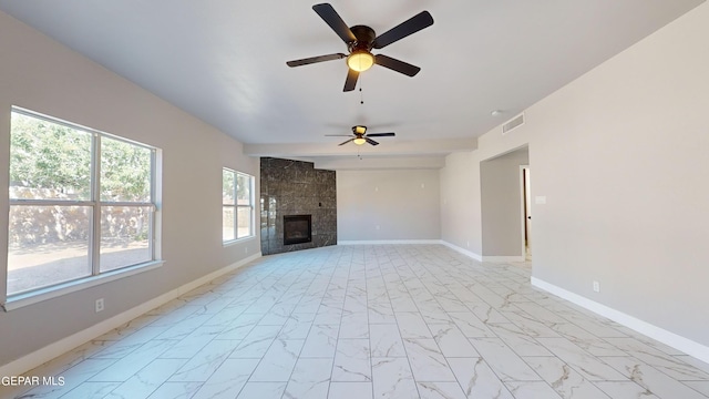 unfurnished living room featuring a tile fireplace and ceiling fan