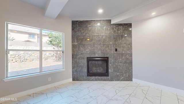 details featuring beam ceiling and a tile fireplace