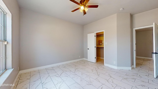 unfurnished bedroom with a closet, a walk in closet, and ceiling fan