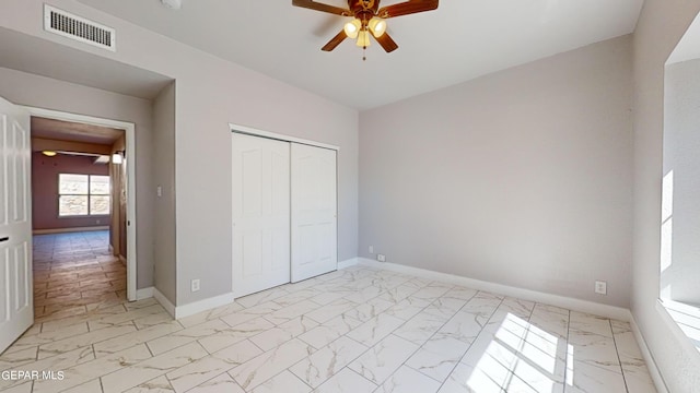 unfurnished bedroom with ceiling fan and a closet